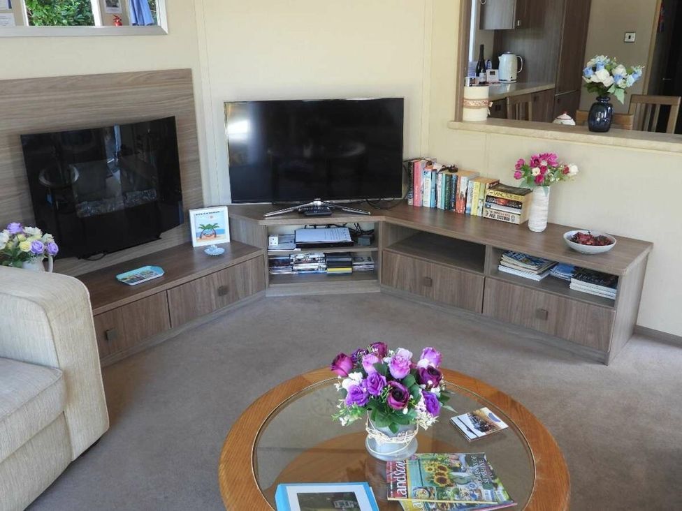 A living room with a sofa and television at Lifes A Beach in Holt