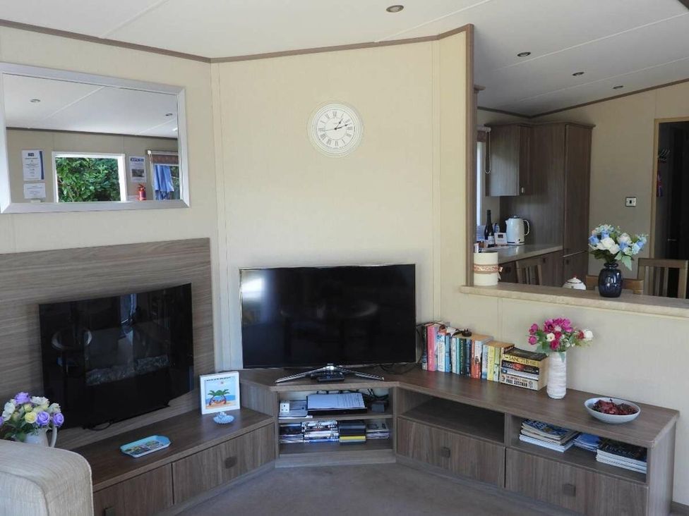 A living room with two televisions and a bookshelf at Lifes A Beach in Holt