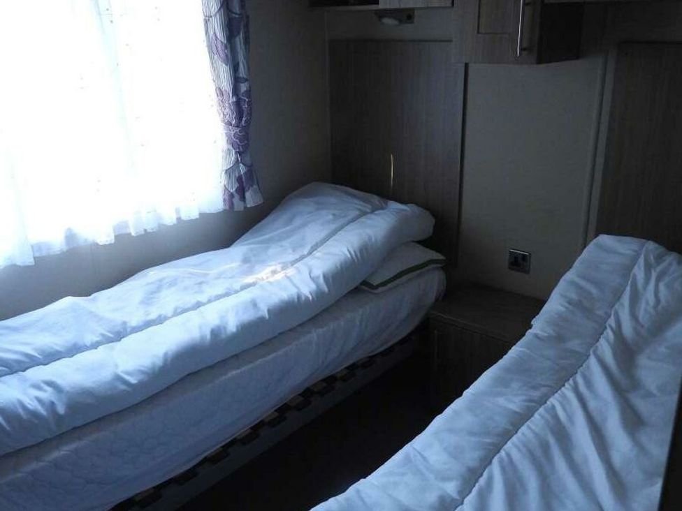 A bedroom with two beds and a window at Lifes A Beach in Holt
