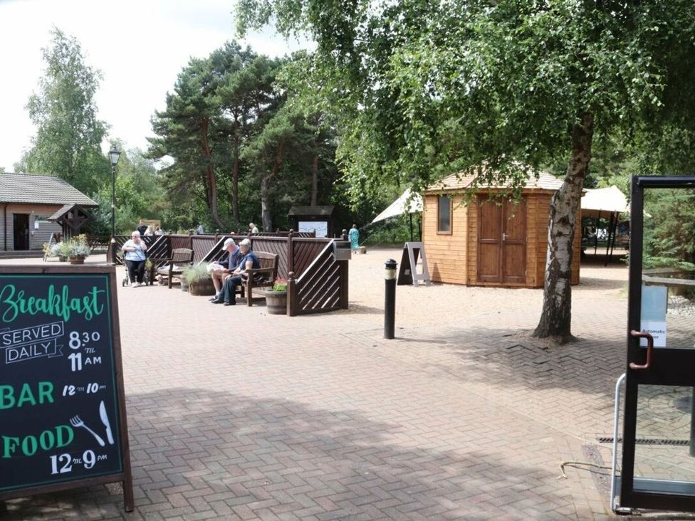 An outdoor area with benches and a signboard at Living The Dream in Holt