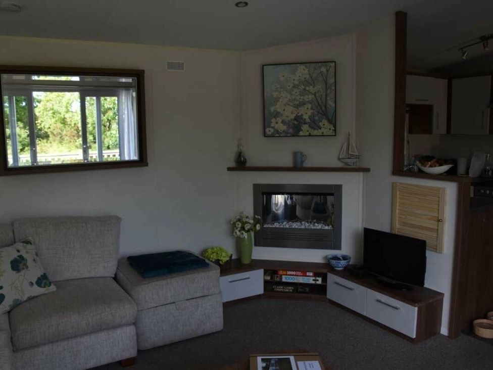 A living room with a sofa and fireplace at Another Day In Paradise in Holt