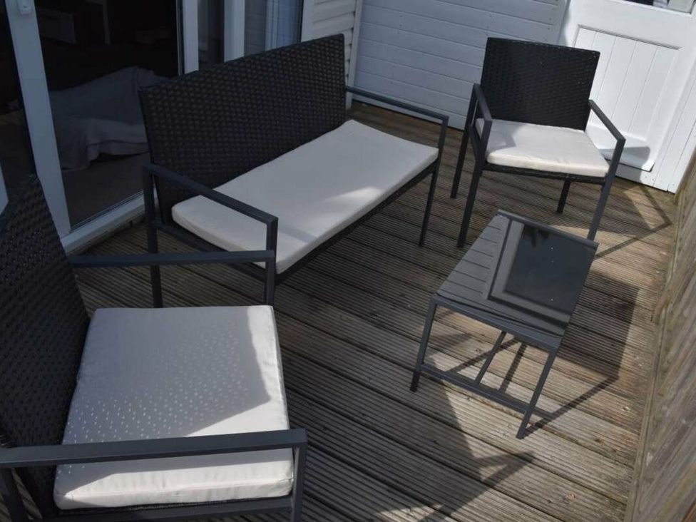 An outdoor seating area with a sofa and chairs at Another Day In Paradise in Holt