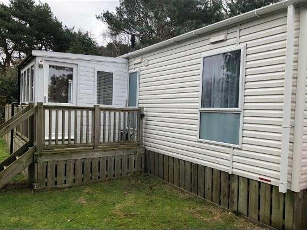An exterior view of a mobile home with a wooden deck at Another Day In Paradise, Holt