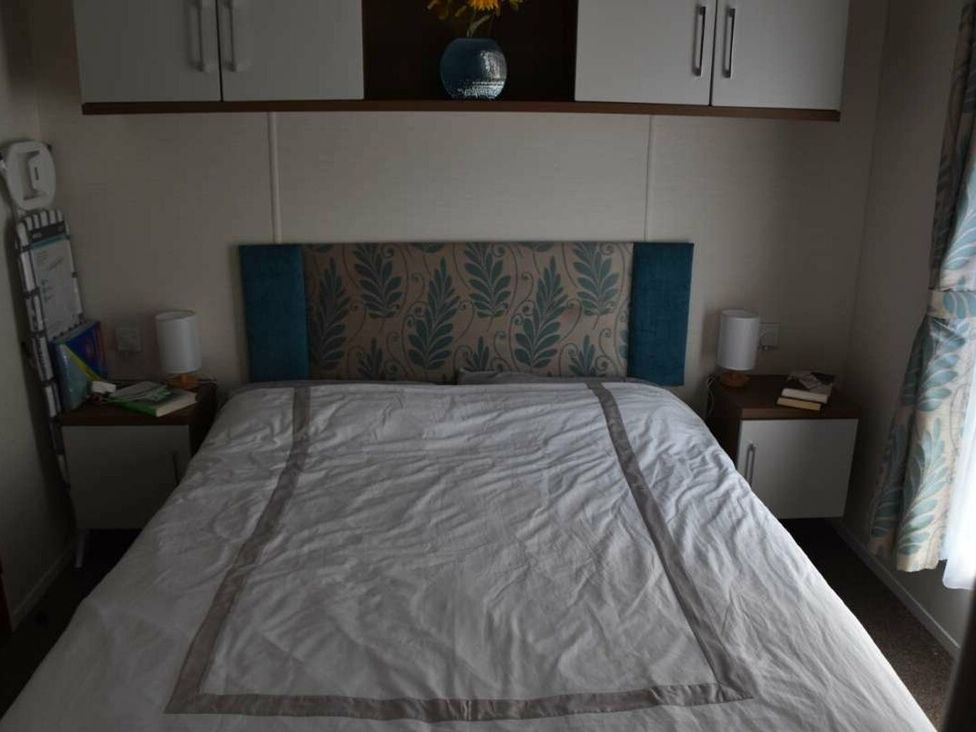 A bedroom with a bed and bedside tables at Another Day In Paradise in Holt