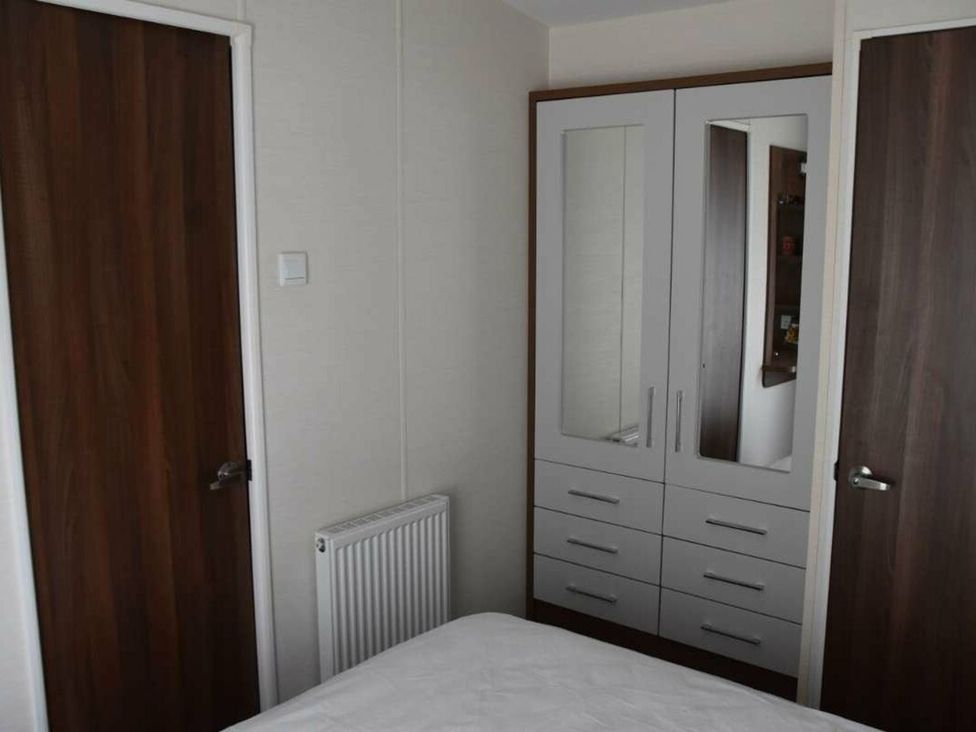 A bedroom with wardrobe and doors at Another Day In Paradise in Holt
