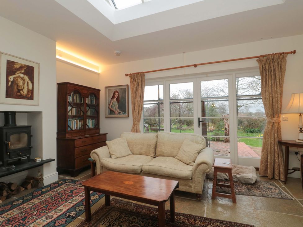 A living room with a sofa and a table at Tuxwell Lodge in Spaxton near Nether Stowey