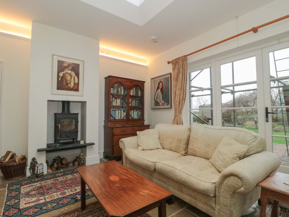 A living room with a sofa and fireplace at Tuxwell Lodge Spaxton near Nether Stowey