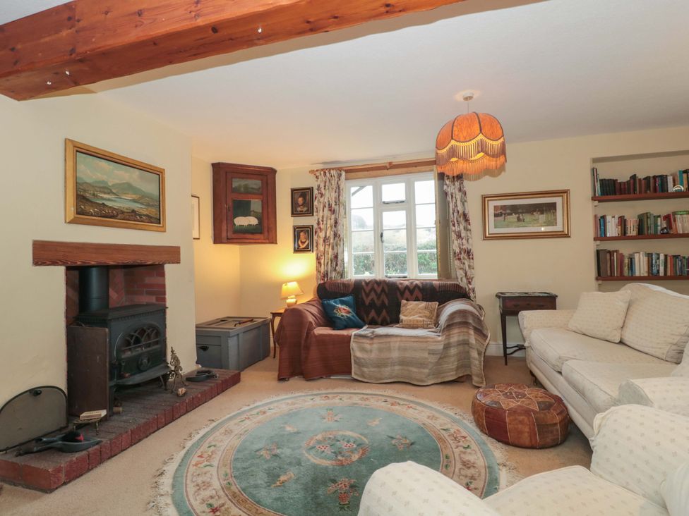 A living room with a fireplace and bookshelf at Tuxwell Lodge Spaxton near Nether Stowey