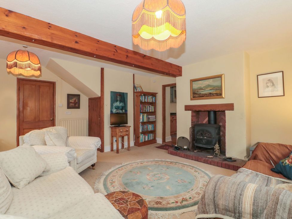 A living room with a television and bookshelf at Tuxwell Lodge in Spaxton near Nether Stowey