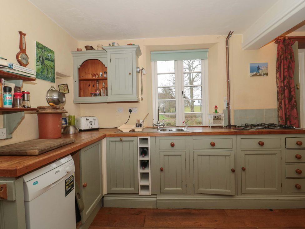 A kitchen with cabinets and sink at Tuxwell Lodge in Spaxton near Nether Stowey