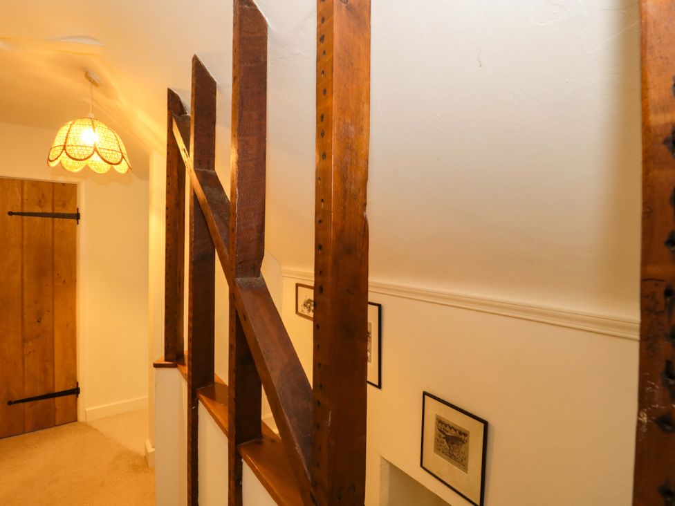 A staircase with wooden railing and door at Tuxwell Lodge Spaxton near Nether Stowey