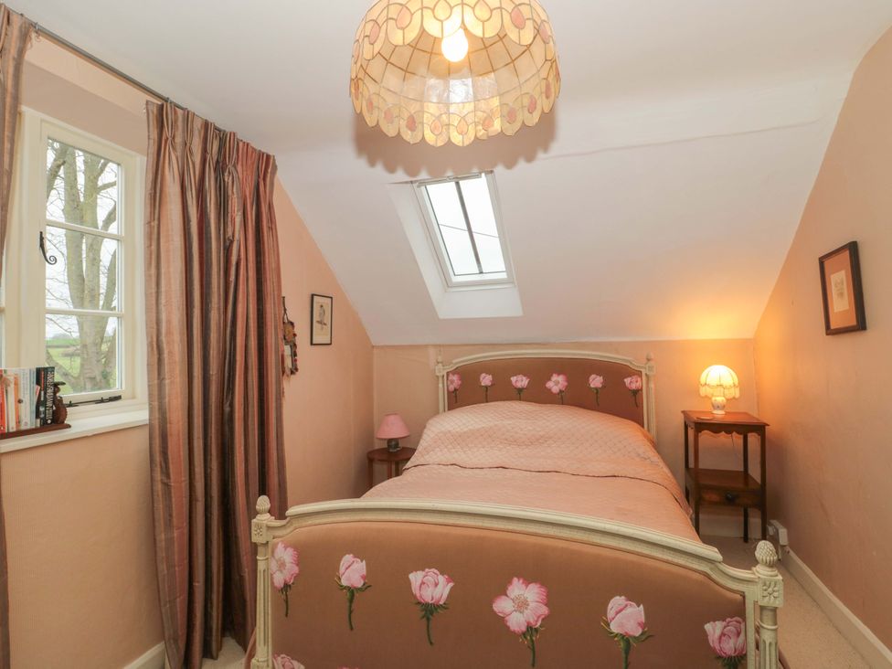 A bedroom with a bed and nightstand at Tuxwell Lodge Spaxton near Nether Stowey