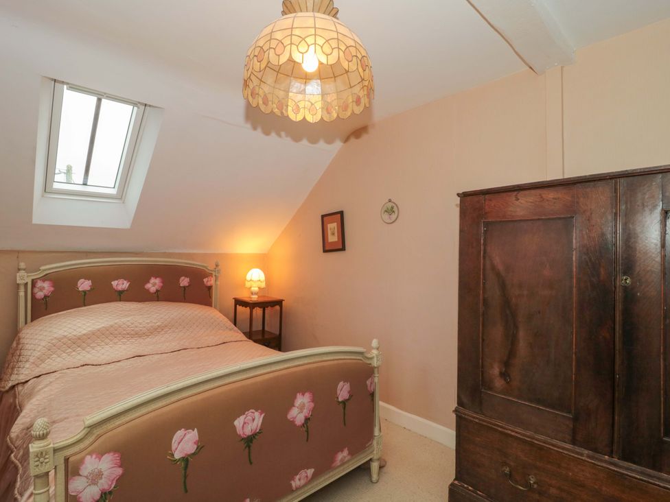 A bedroom with a bed and nightstand at Tuxwell Lodge in Spaxton near Nether Stowey