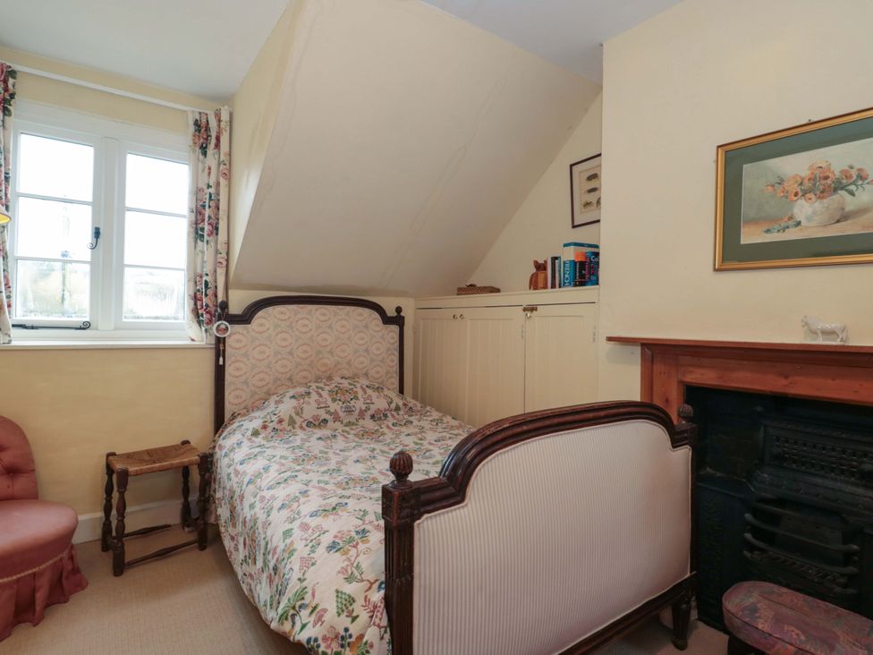 A bedroom with a bed and an armchair at Tuxwell Lodge Spaxton near Nether Stowey