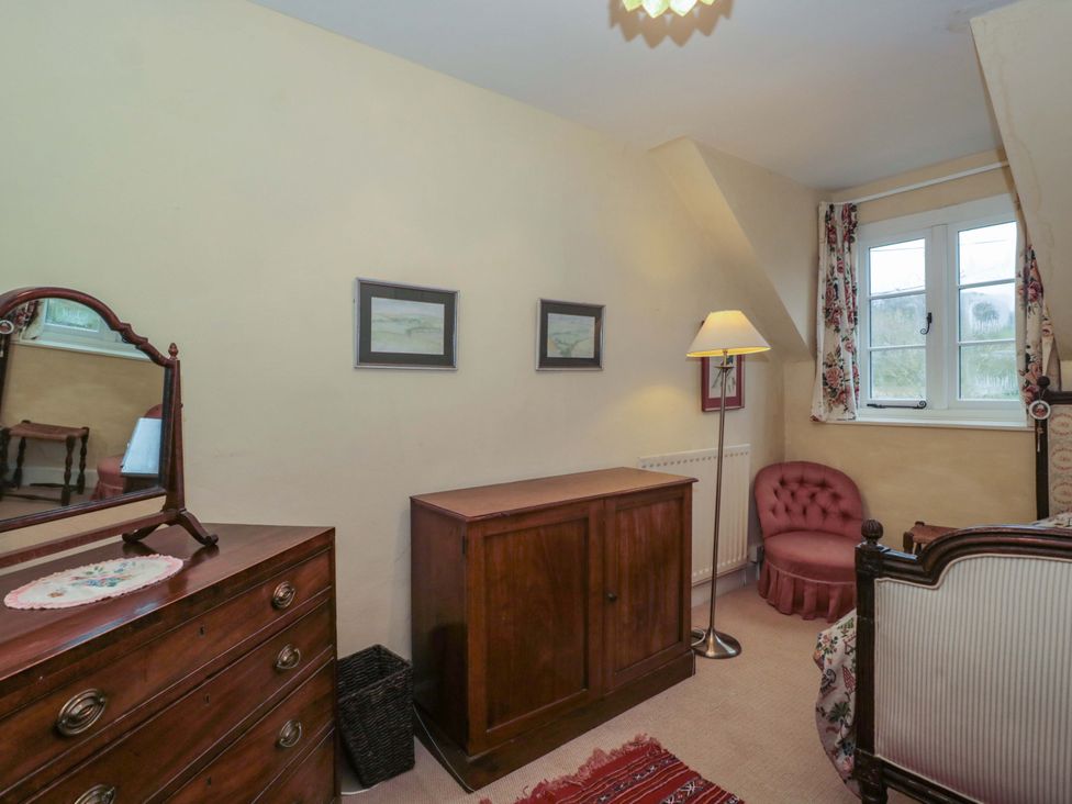 A bedroom with furniture including a bed and dressing table at Tuxwell Lodge Spaxton near Nether Stowey
