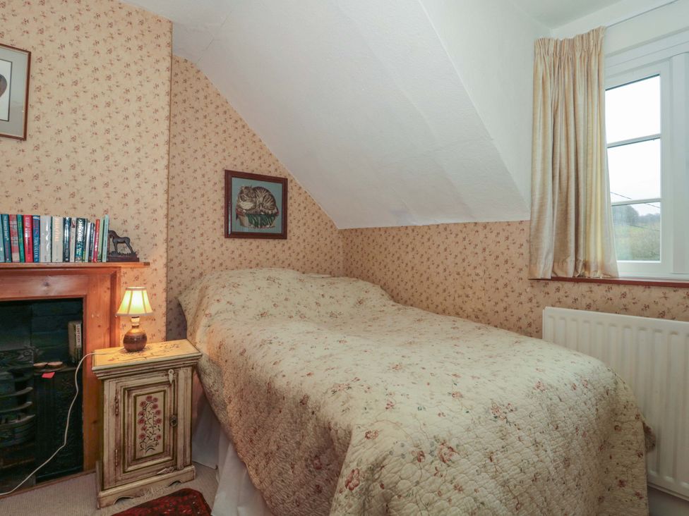 A bedroom with a bed and bookshelf at Tuxwell Lodge in Spaxton near Nether Stowey