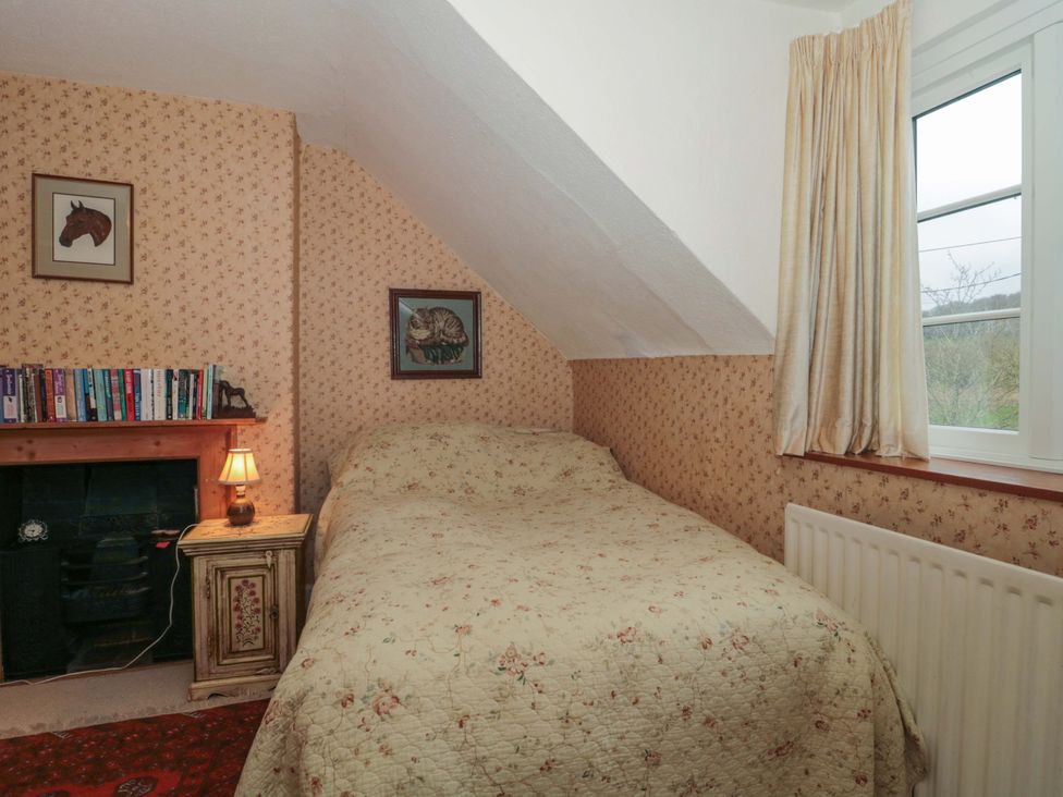 A bedroom with a bed and bookshelf at Tuxwell Lodge Spaxton near Nether Stowey