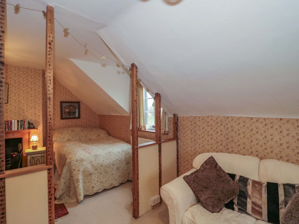 A bedroom with a bed and sofa at Tuxwell Lodge in Spaxton near Nether Stowey