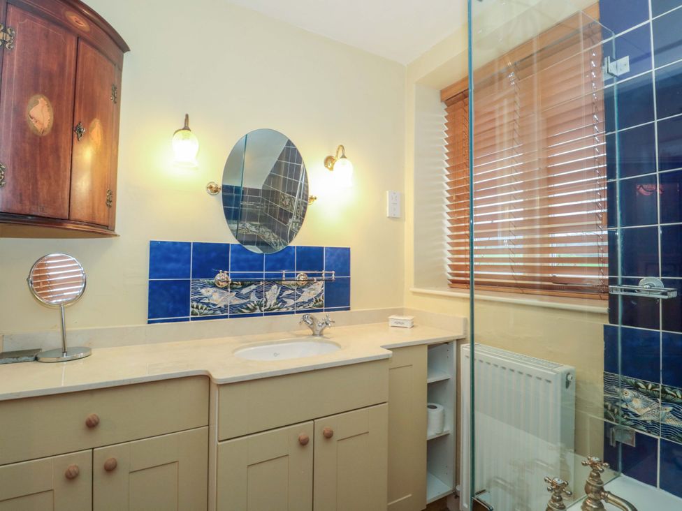 A bathroom with a sink and mirror at Tuxwell Lodge in Spaxton near Nether Stowey
