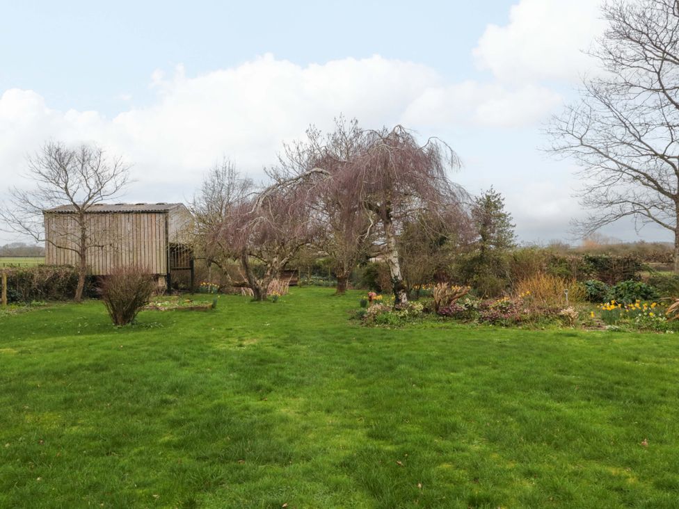 A garden with trees and a shed at Tuxwell Lodge Spaxton near Nether Stowey