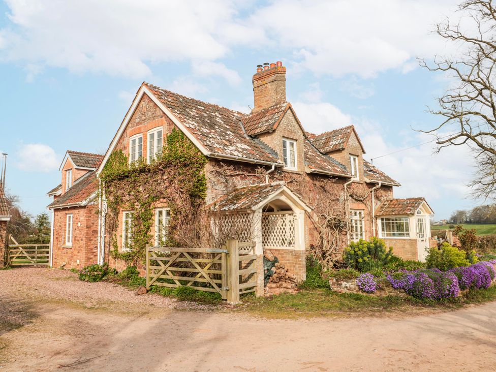 A house with a gate and flowers near the entrance at Tuxwell Lodge near Nether Stowey