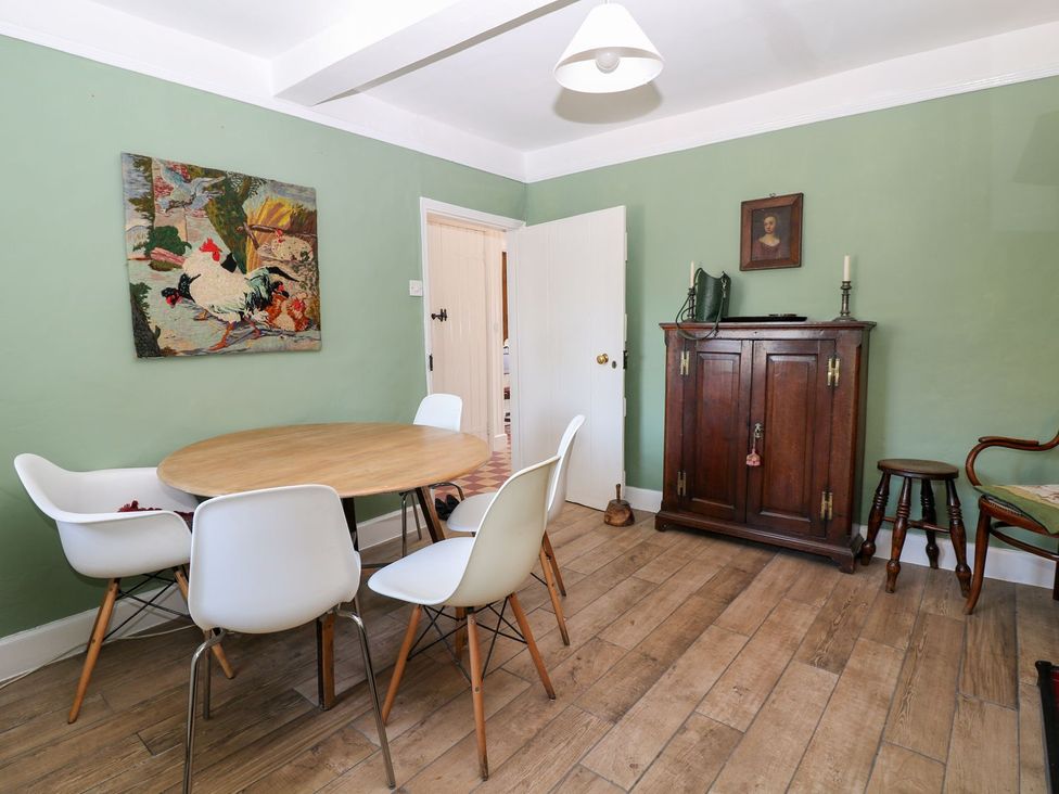 A dining room with a round table and chairs at Ivy Cottage in Hartington