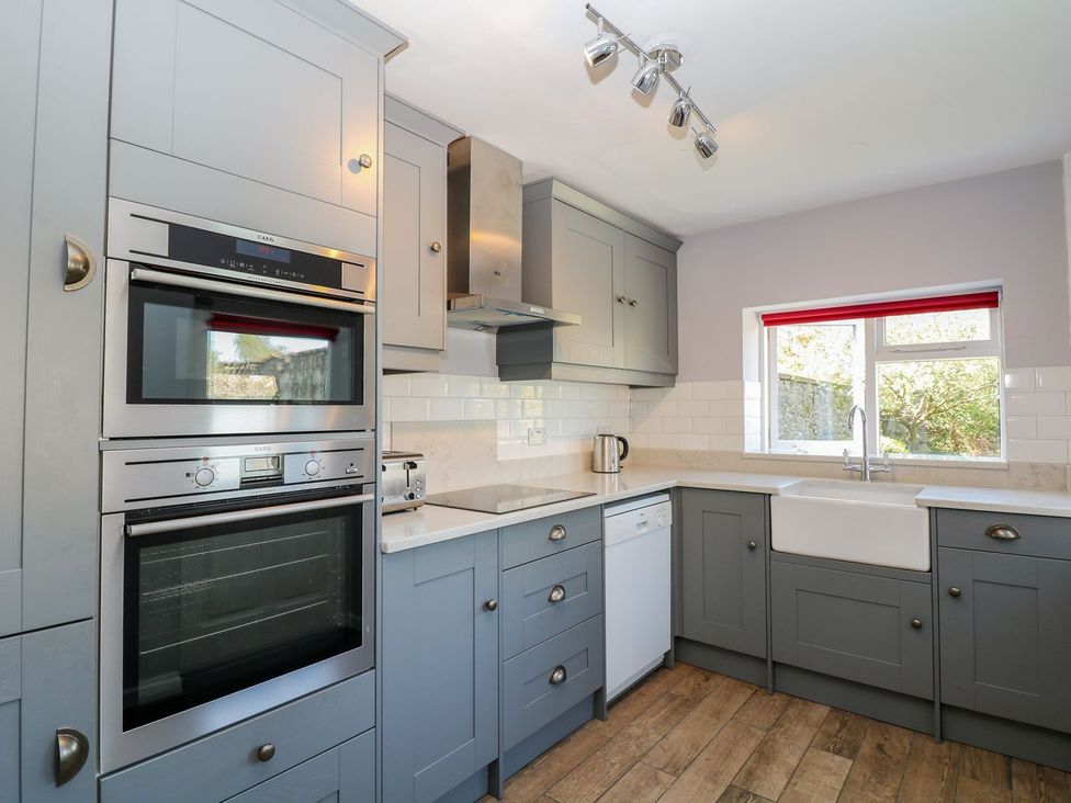 A kitchen with cabinets and appliances at Ivy Cottage in Hartington
