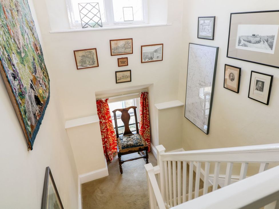 A stairwell with a window and chair at Ivy Cottage in Hartington