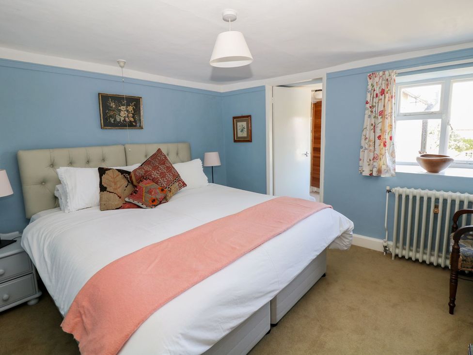 A bedroom with a bed and window at Ivy Cottage in Hartington