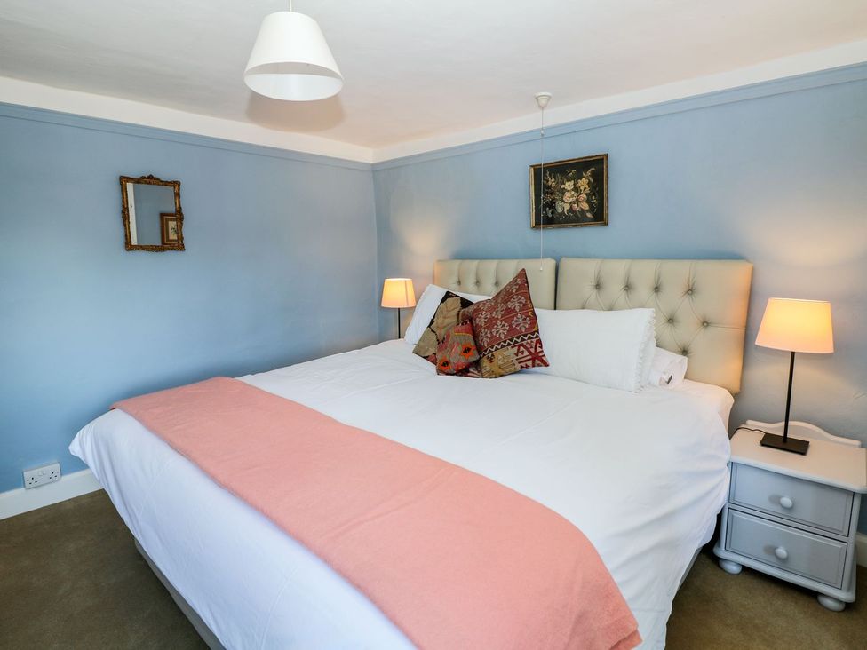 A bedroom with a bed and bedside lamps at Ivy Cottage in Hartington