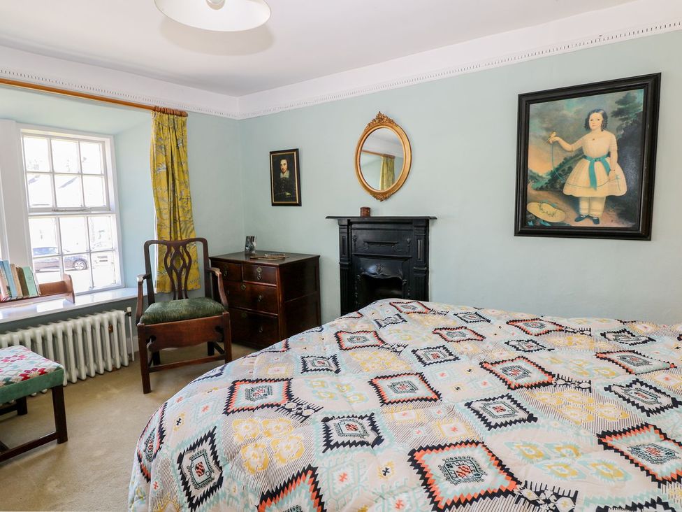 A bedroom with a bed and a chair at Ivy Cottage in Hartington