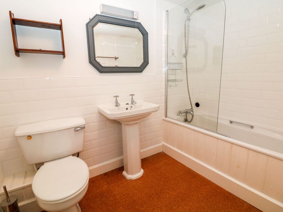 A bathroom featuring a toilet, sink, mirror, and shower at Ivy Cottage Hartington