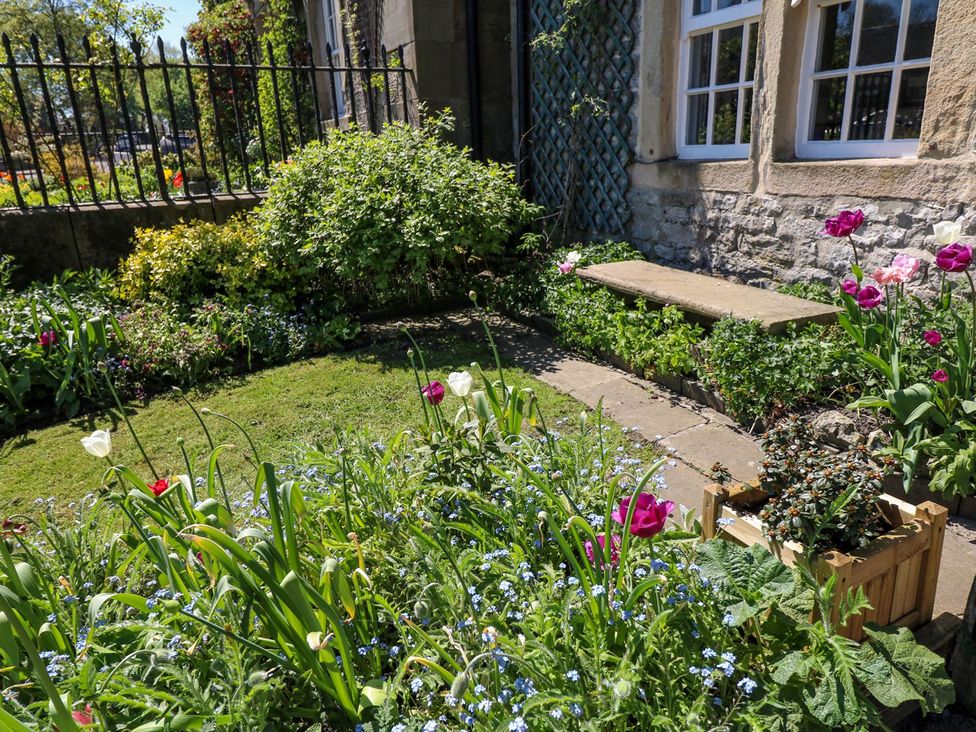 A garden with flowers and stone steps at Ivy Cottage in Hartington