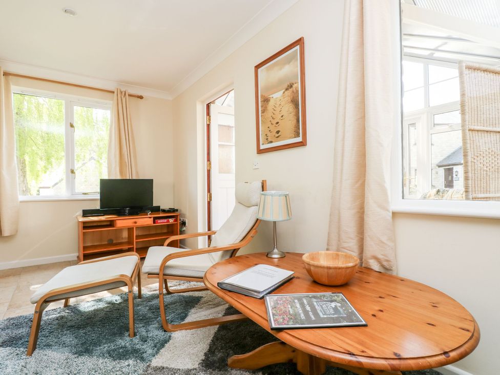 A snug room with a television and seating area at Oak Cottage in Falmouth