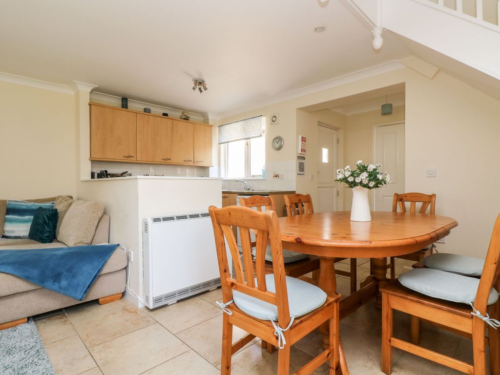 A kitchen with a dining table and chairs at Oak Cottage in Falmouth