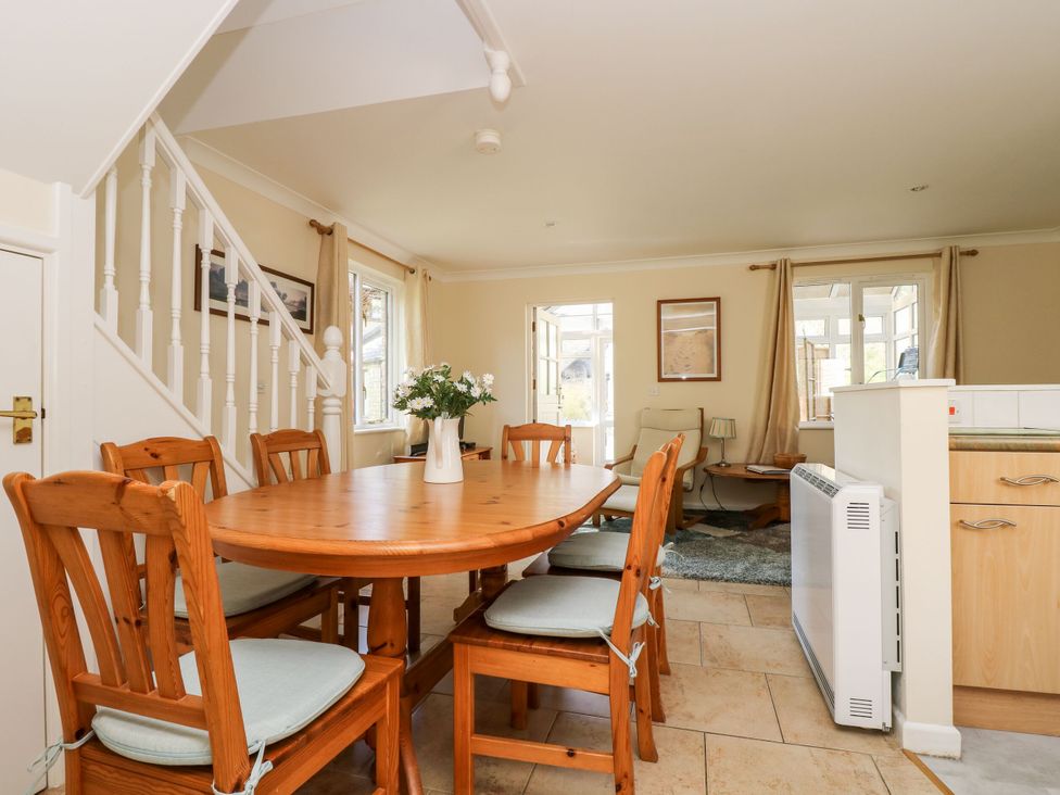 A dining room with a wooden table and chairs at Oak Cottage in Falmouth