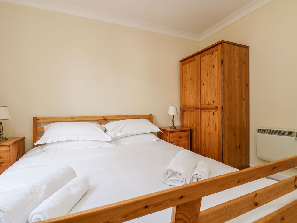 A bedroom with a bed and wardrobe at Oak Cottage in Falmouth