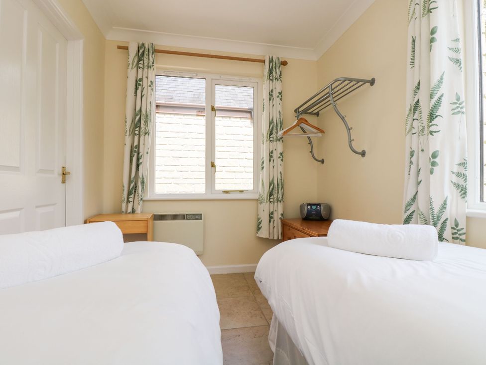 A bedroom with two beds and a window at Oak Cottage in Falmouth