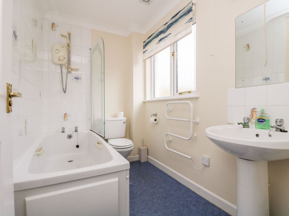 A bathroom with a bathtub, toilet, and sink at Oak Cottage in Falmouth