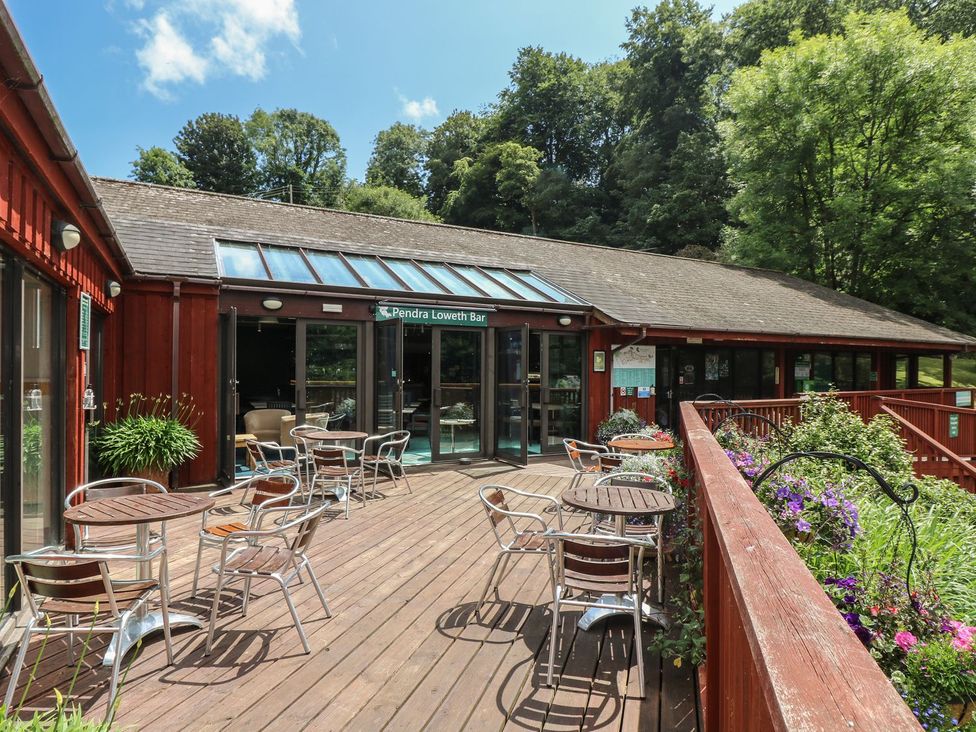 An outdoor seating area with chairs and a bar entrance at Oak Cottage in Falmouth