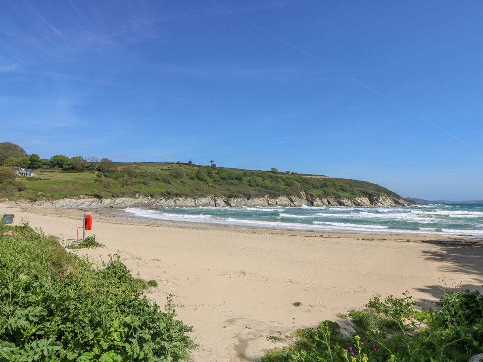 A beach with sand and sea waves at Oak Cottage in Falmouth