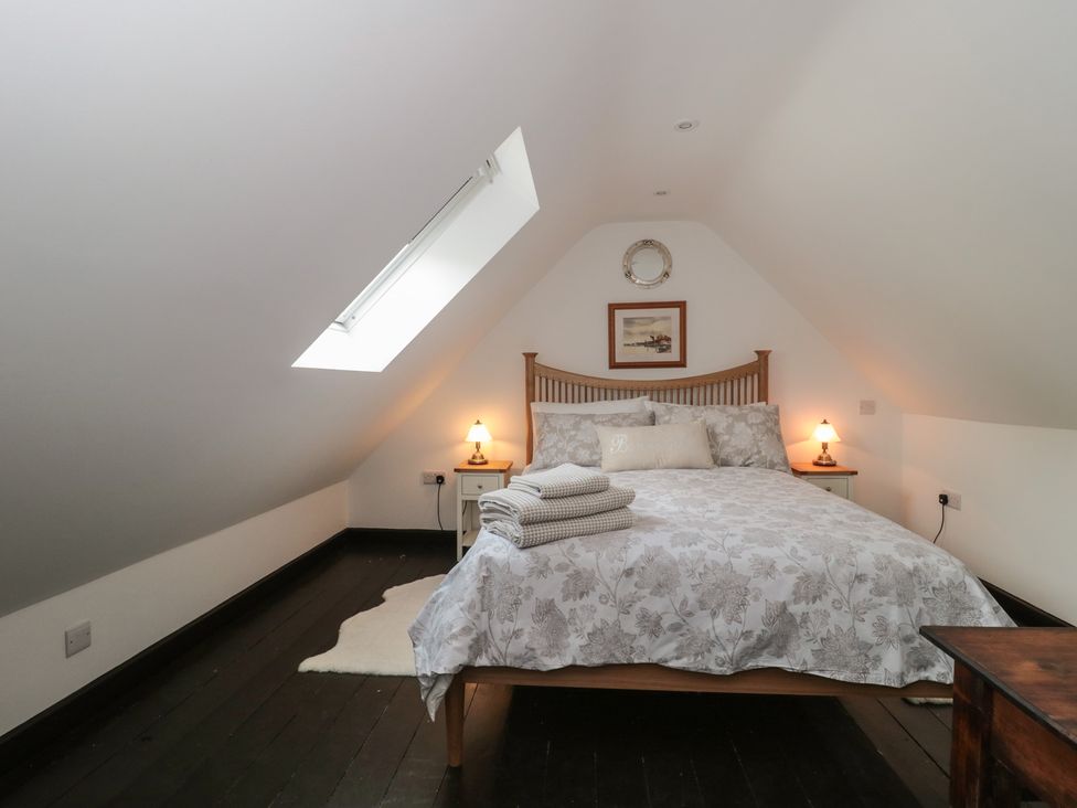 A bedroom with a bed and artwork at Ruby’s Den Ashton Keynes