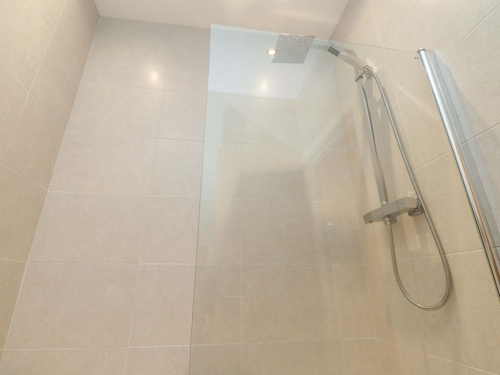 A shower with glass panel and tiled walls in Flat 2, Dorstan Carnforth