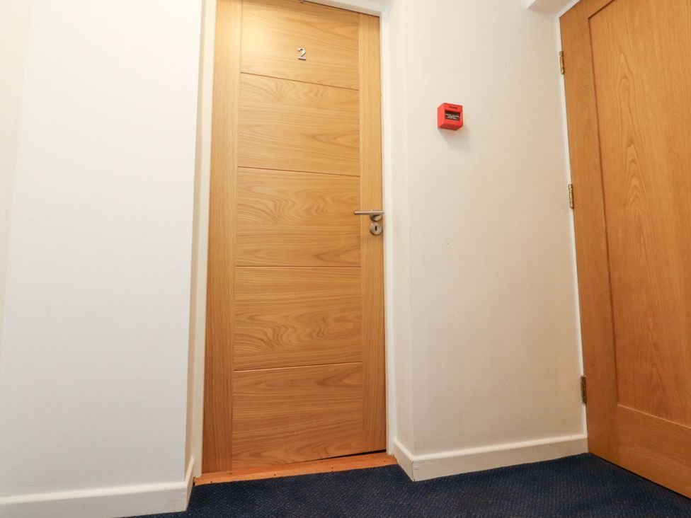 A hallway with a wooden door marked 2 at Flat 2, Dorstan in Carnforth