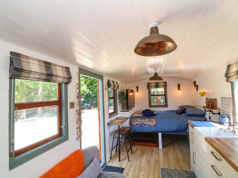 A bedroom with a bed and table at Shepherds Hut in South Hykeham