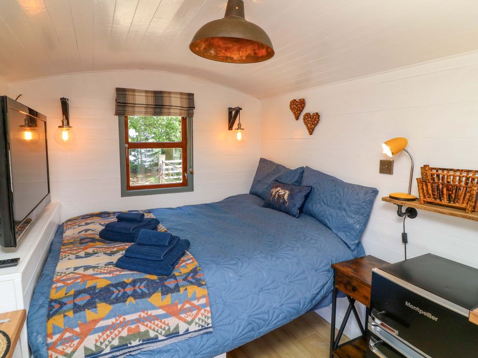 A bedroom with a bed and decor at Shepherds Hut in South Hykeham