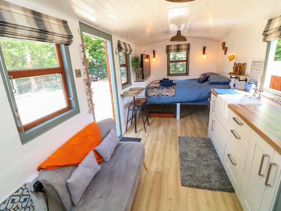 A bedroom with a bed and sofa at Shepherds Hut in South Hykeham