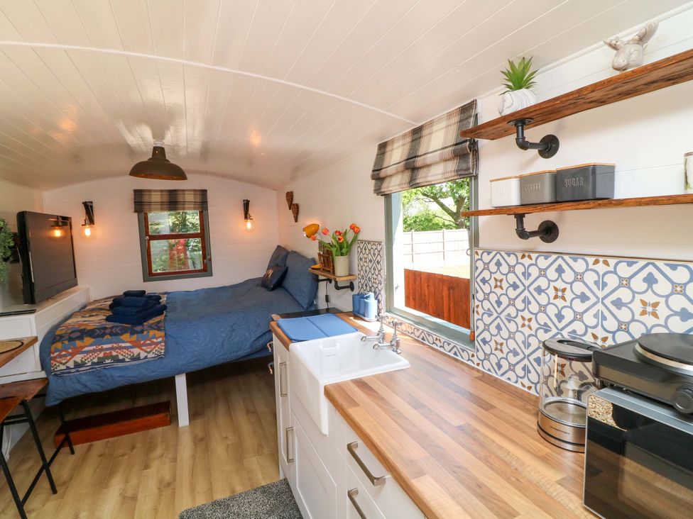 A studio with a bed and kitchen area at Shepherds Hut in South Hykeham