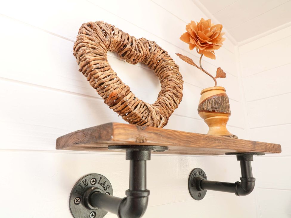 A shelf with a wreath and flower vase at Shepherds Hut in South Hykeham