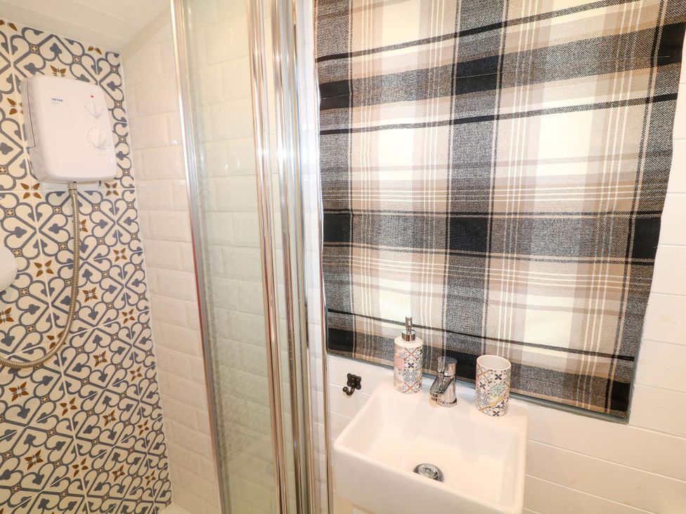 A bathroom with a shower and sink at Shepherds Hut in South Hykeham